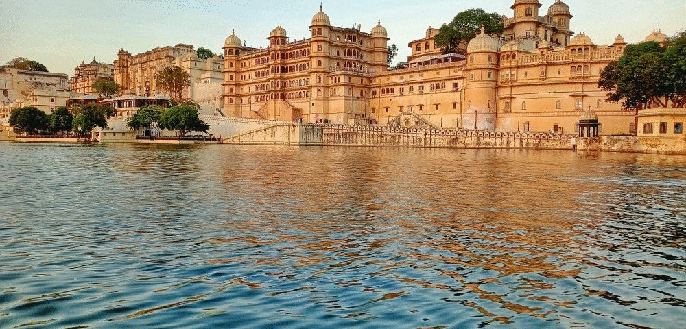 Lake Pichola in Udaipur with calm waters, historic palaces, and surrounding Aravalli h